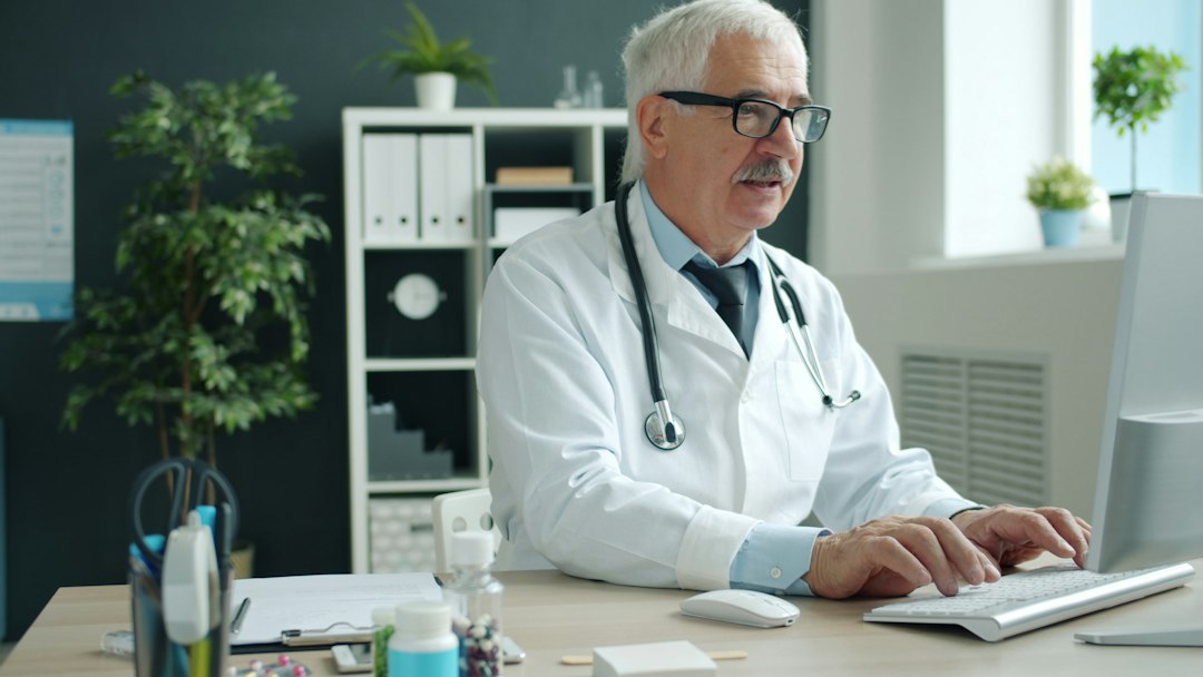 Medical billing specialist working at a computer in a clinic office